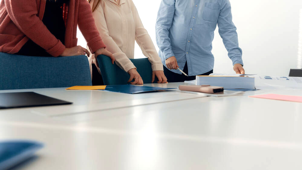 Kuvassa on henkilöitä neuvottelupöydän ääressä